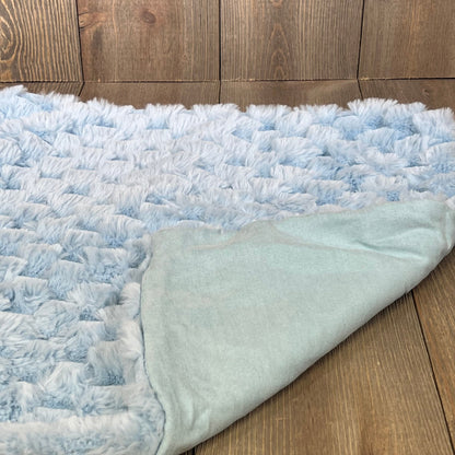 Light blue plush faux fur pillow cover showcasing soft texture on a wooden background, perfect for sofa or bed decor.