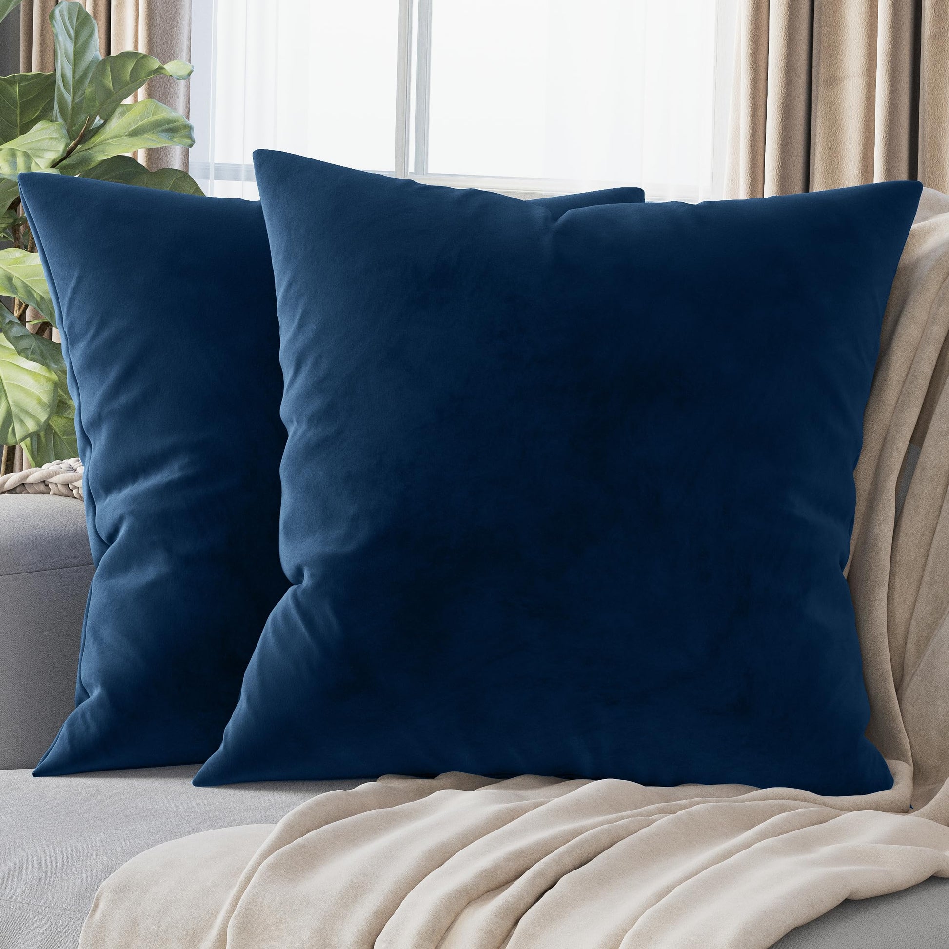 Dark blue velvet pillow covers 22x22 on a couch, adding luxury and comfort to living room decor. Set of 2 washable covers.