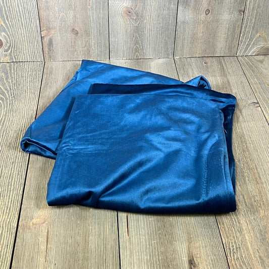 Dark blue velvet pillow covers on a wooden surface, showcasing luxurious texture and rich color, perfect for home decor.