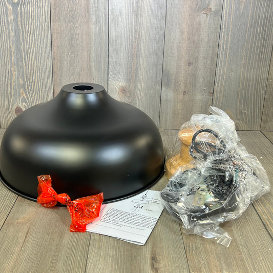 Industrial black gooseneck barn light components and instructions on a wooden surface, ready for assembly.