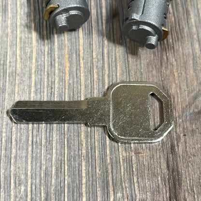 Metal key and lock cylinders for Hihaha car roof rack, compatible with Yakima system, displayed on a wooden surface.