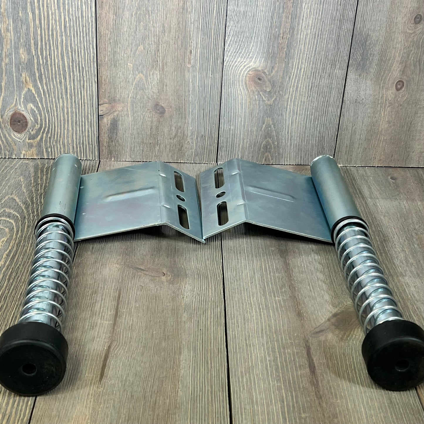 Garage door plunger bumper springs with metal plates on wooden background, part of the LAJIAOZ opener system.