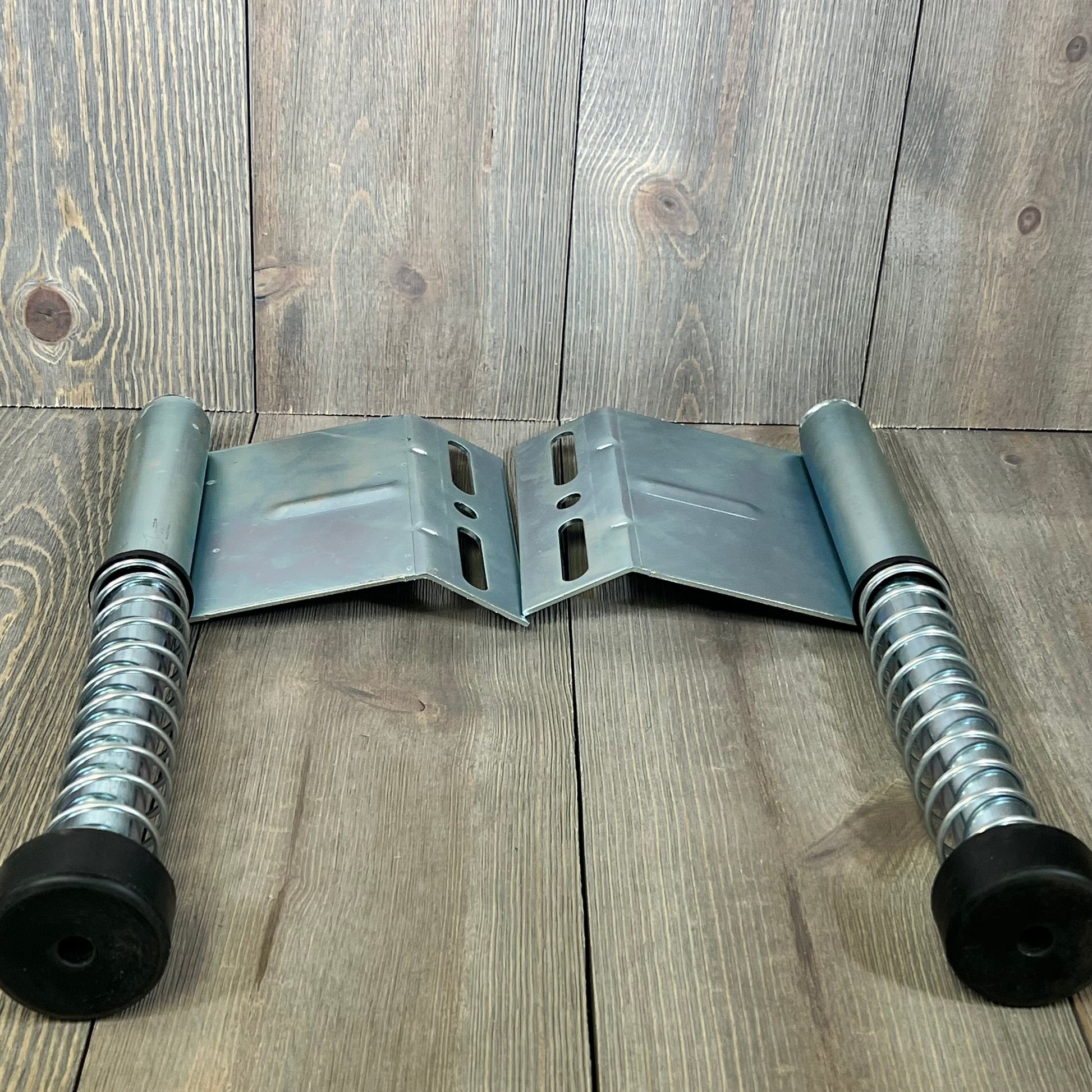 Garage door plunger bumper springs with metal plates on wooden background, part of the LAJIAOZ opener system.
