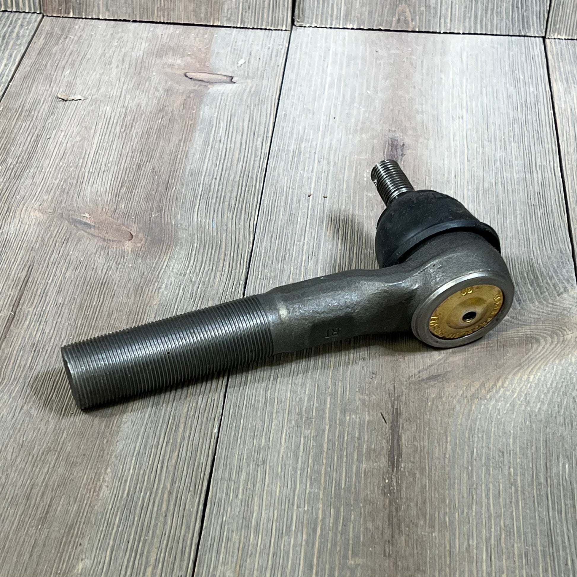 MOOG ES3625 Steering Tie Rod End for Dodge Ram 2500, showcasing threaded metal rod and joint on wooden surface.