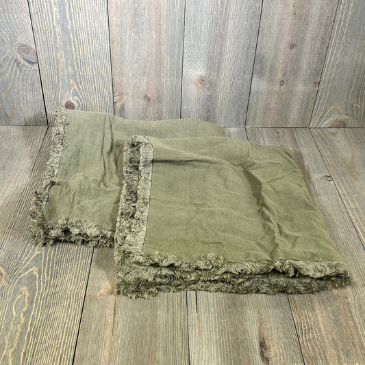 Olive green linen fringe throw pillow covers on a rustic wooden background, perfect for boho farmhouse decor.
