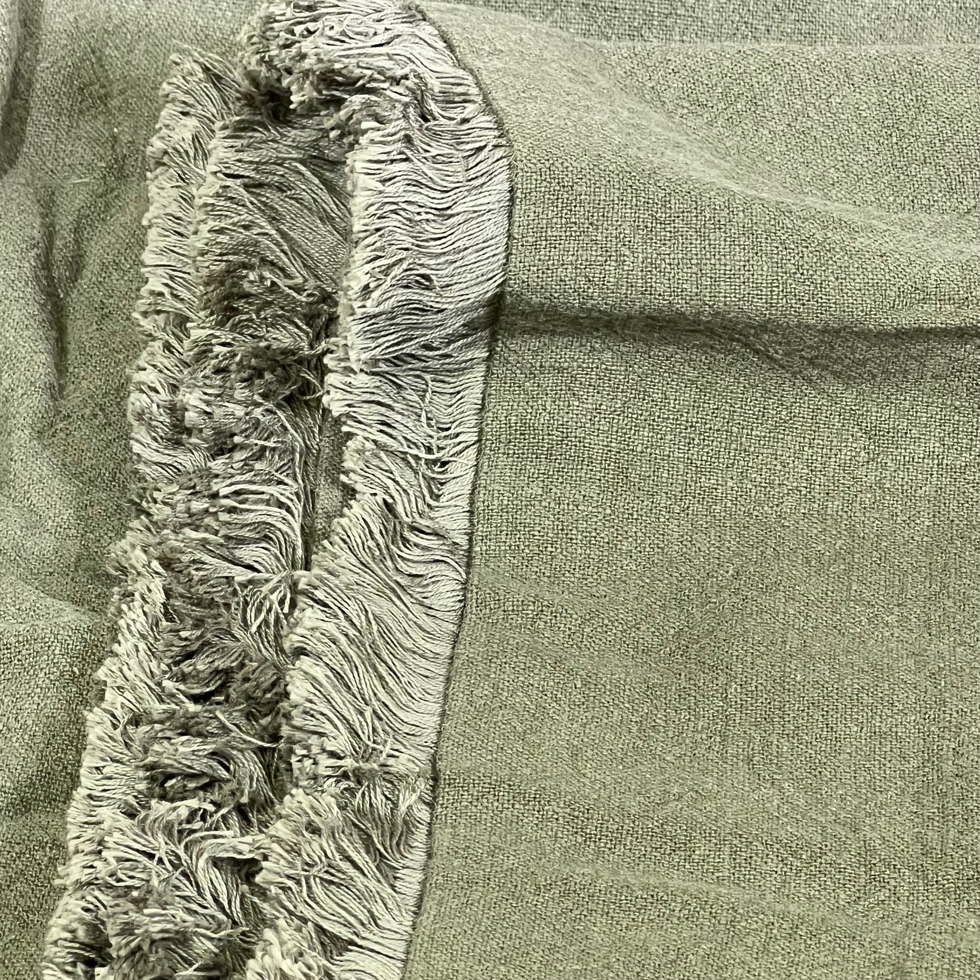 Olive green linen pillow cover with fringe detail, perfect for boho farmhouse decor in living rooms and bedrooms.