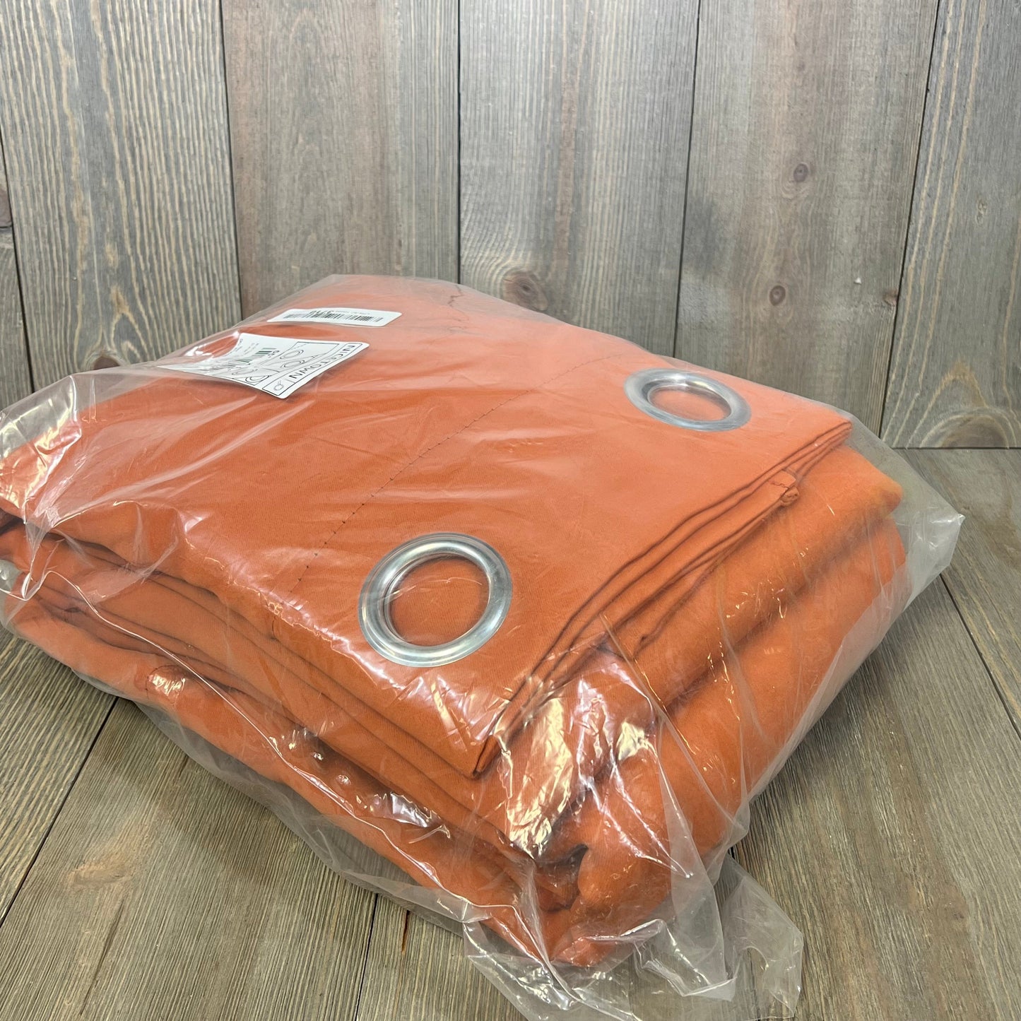 Burnt orange NICETOWN blackout curtains in packaging, featuring heavy-duty fabric and silver grommets for bedroom privacy.