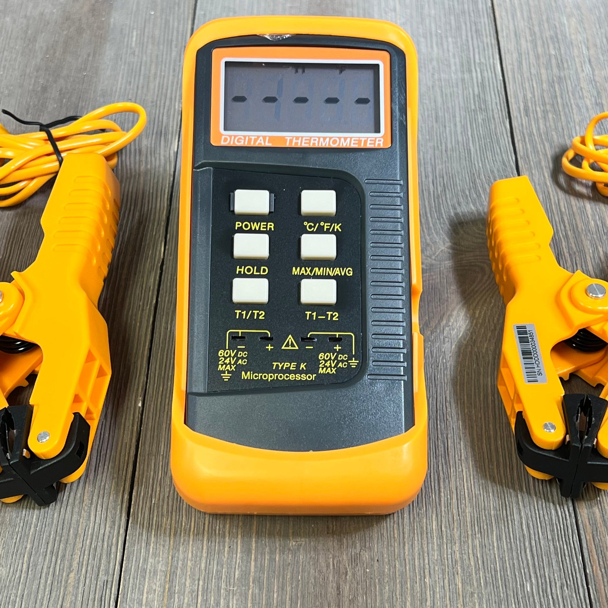 Dual-channel K Type Thermocouple Thermometer with two orange temperature clamps on a wooden surface.