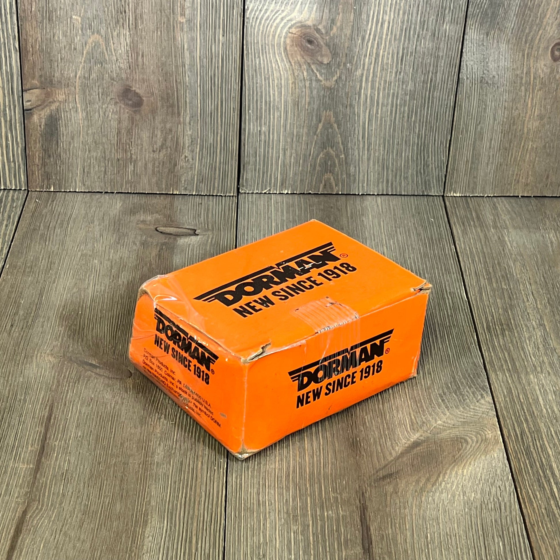 Dorman 610-383 wheel stud box on wood background, showcasing durable packaging for Dodge models, 10 pack.