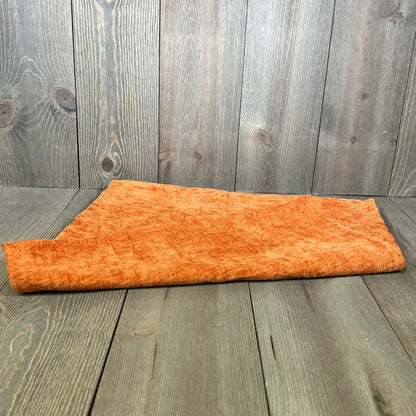 Soft chenille rust pillow cover displayed on wooden floor, perfect for enhancing living room decor.