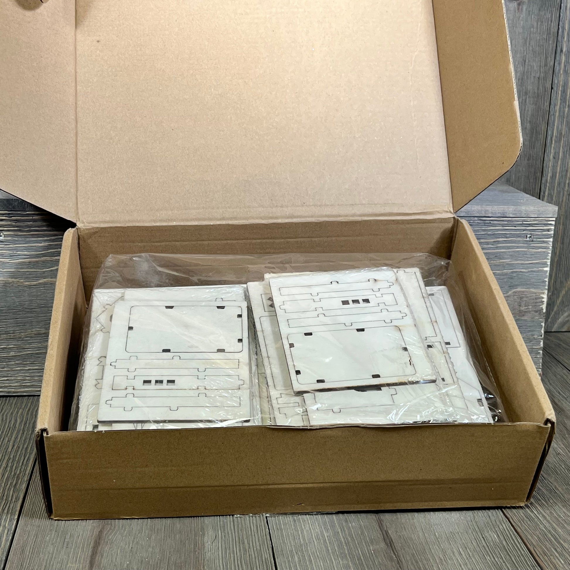 Open box displaying Hiboom DIY Christmas Village wood pieces, perfect for crafting rustic church mini houses for holiday decor.
