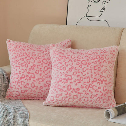 Pink leopard print pillow covers on a beige sofa, showcasing soft flannel fleece texture, perfect for couch decor.