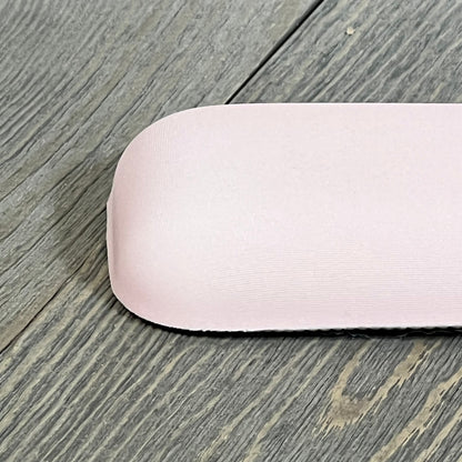 Ergonomic apricot wrist rest on wooden surface, featuring a curved memory foam design for comfort and pain relief.