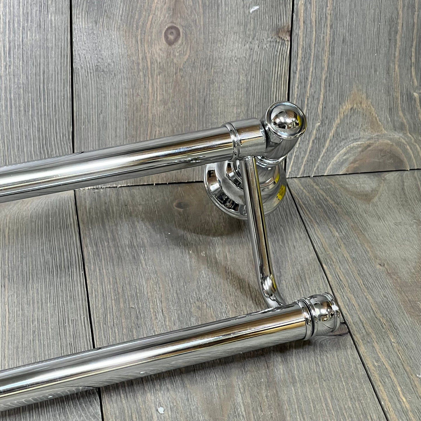 Polished nickel double towel bars with elegant design on wooden background, perfect for traditional bathroom decor.