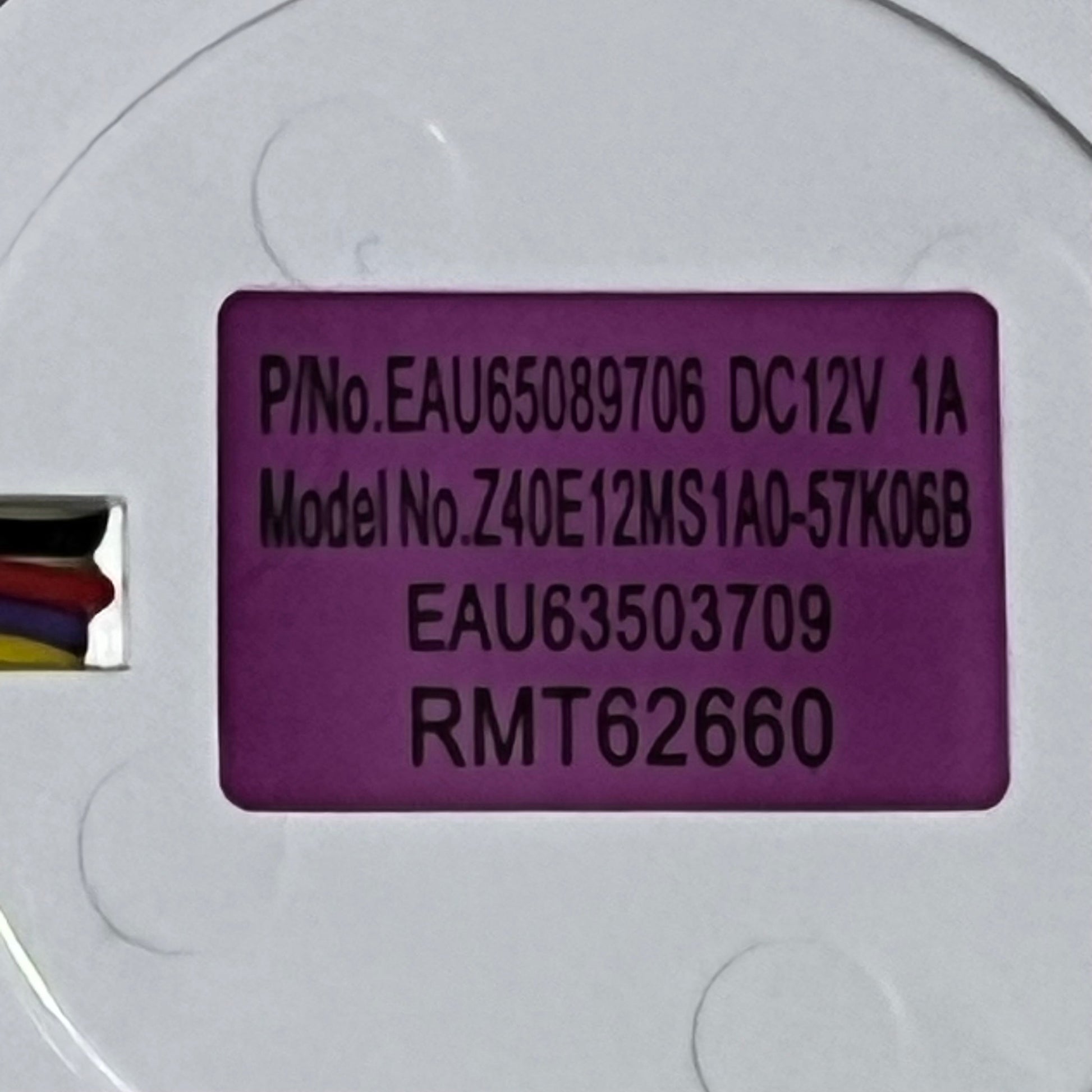 Close-up of LG refrigerator evaporator fan motor model EAU63503709 label with specifications and wiring details.