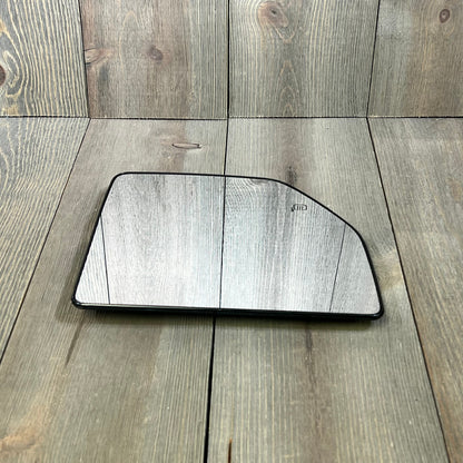 Heated upper mirror glass for 2015-2020 Ford F150, showcasing the replacement's sleek design on a wooden background.