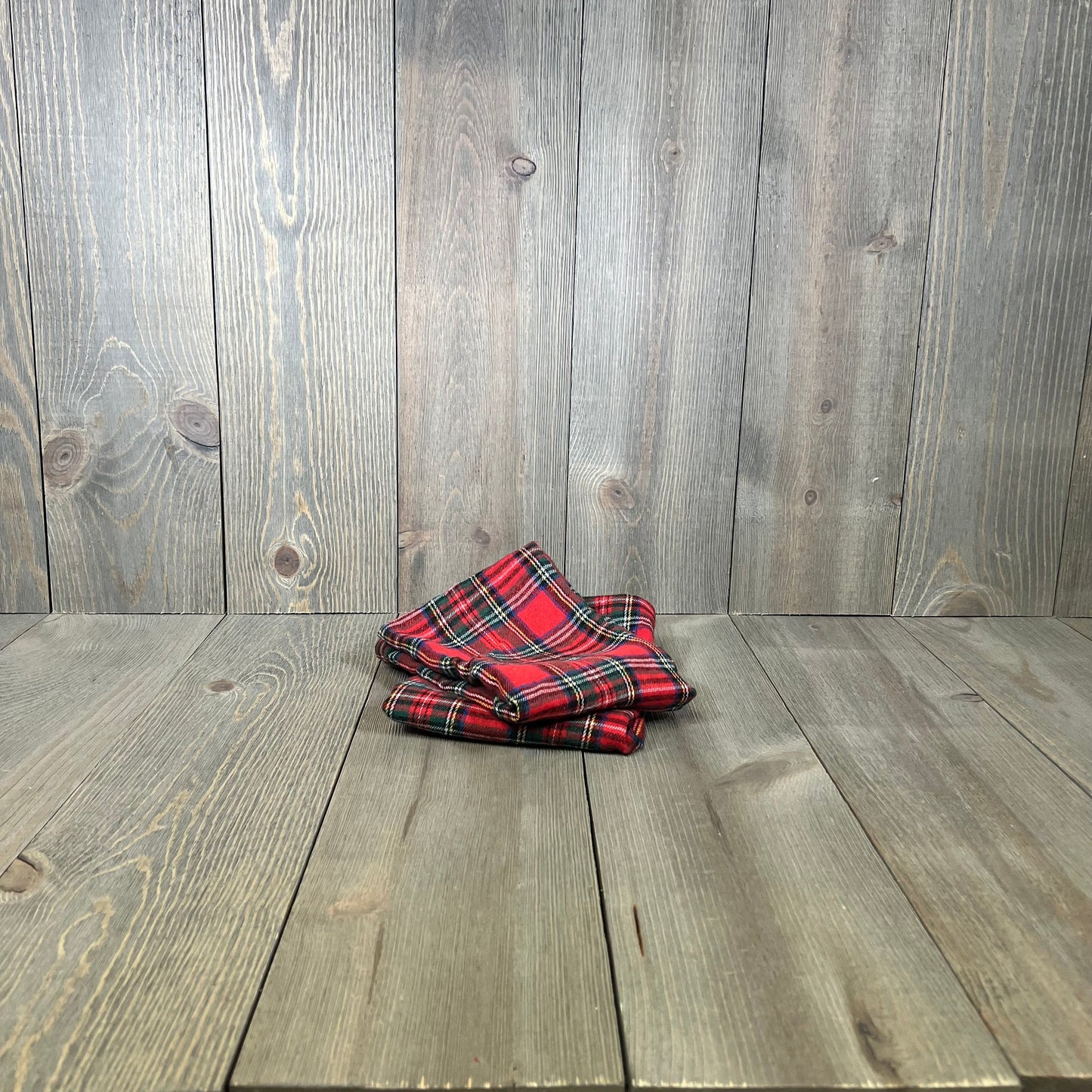 Red Scottish tartan plaid pillow covers on wooden floor, perfect for farmhouse Christmas decor.