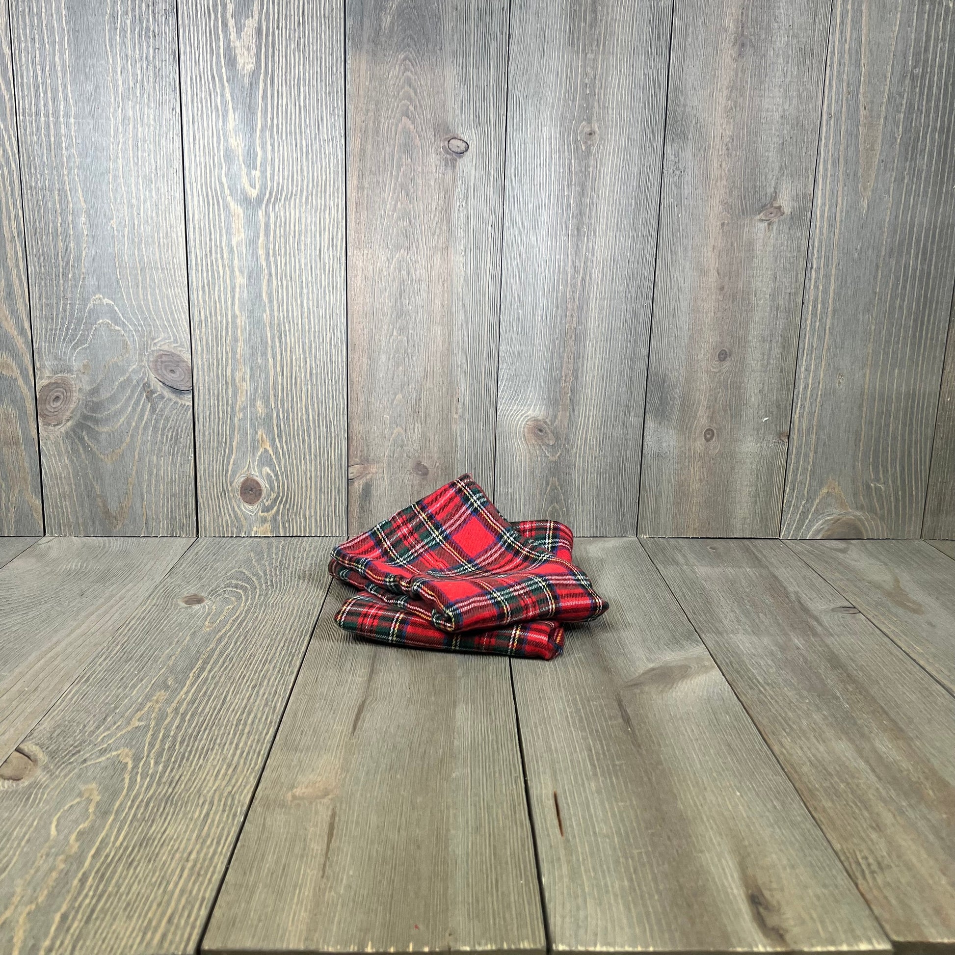 Red Scottish tartan plaid pillow covers on wooden floor, perfect for farmhouse Christmas decor.