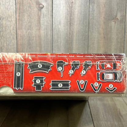 SCX Extreme Raiders Slot Car Set packaging, showing track pieces, AC adaptor, and two cars for 1:43 scale racing.