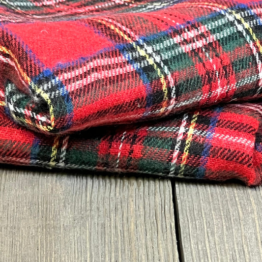 Red Scottish tartan plaid pillow covers, folded on a wooden surface, perfect for festive farmhouse decor.