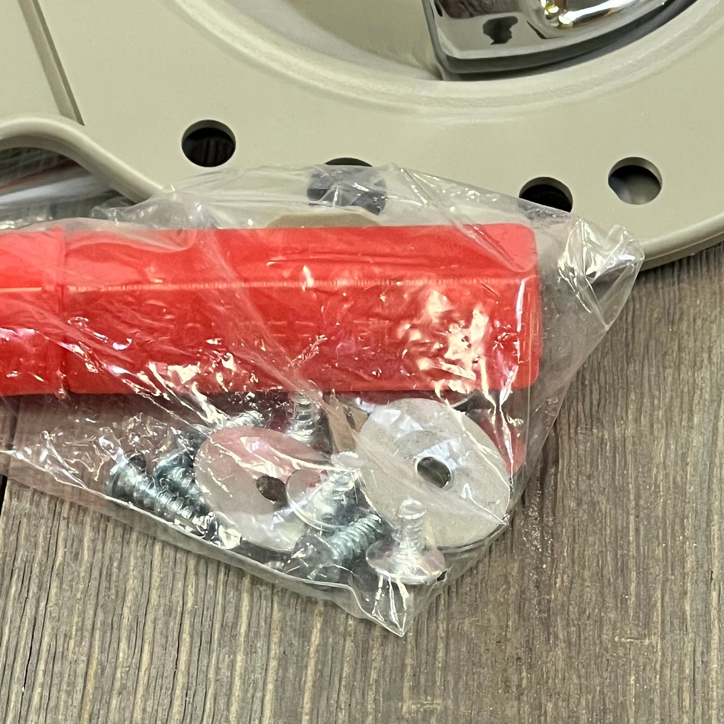 Tan chrome bolt set with washers for Jeep Commander 2006-2010, shown with red plastic packaging on a wooden surface.