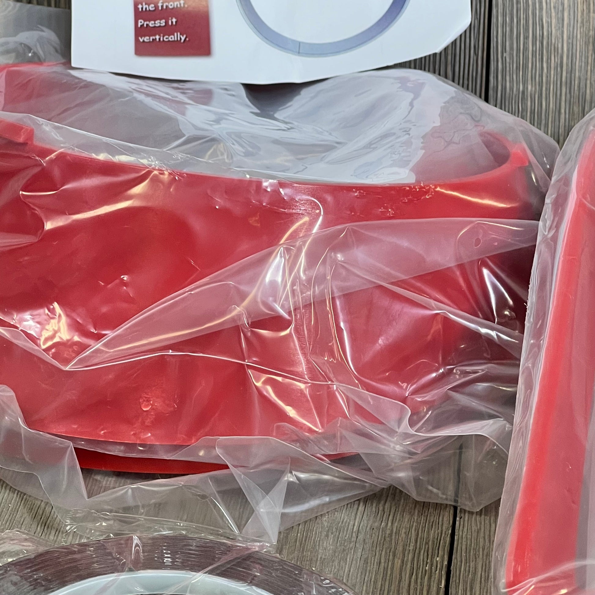 Red clip-in grille guard and headlight bezels for Jeep Wrangler JL JLU Sport 2018-2023, packaged in protective wrap.
