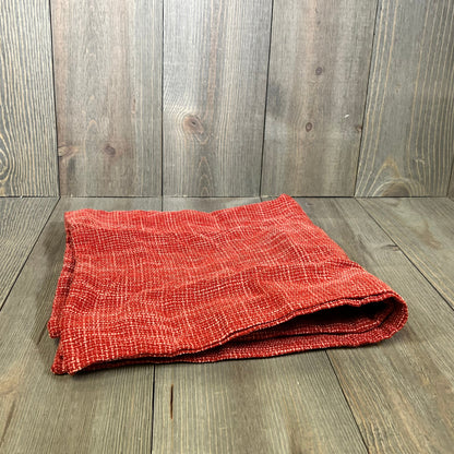 Burnt brick faux linen pillow cover folded on a wooden surface, perfect for modern home decor.