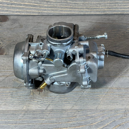 Replacement carburetor for Polaris Sportsman 500, years 1996-1998, on wooden surface. Durable metal construction.