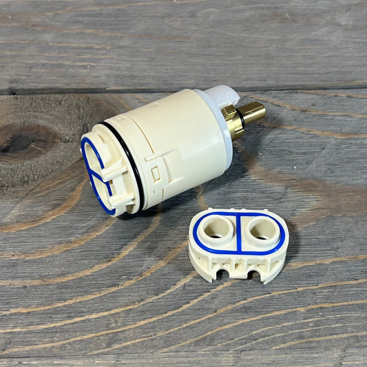 Replacement cartridge and valve assembly for Peerless tub and shower, featuring durable design on wooden surface.