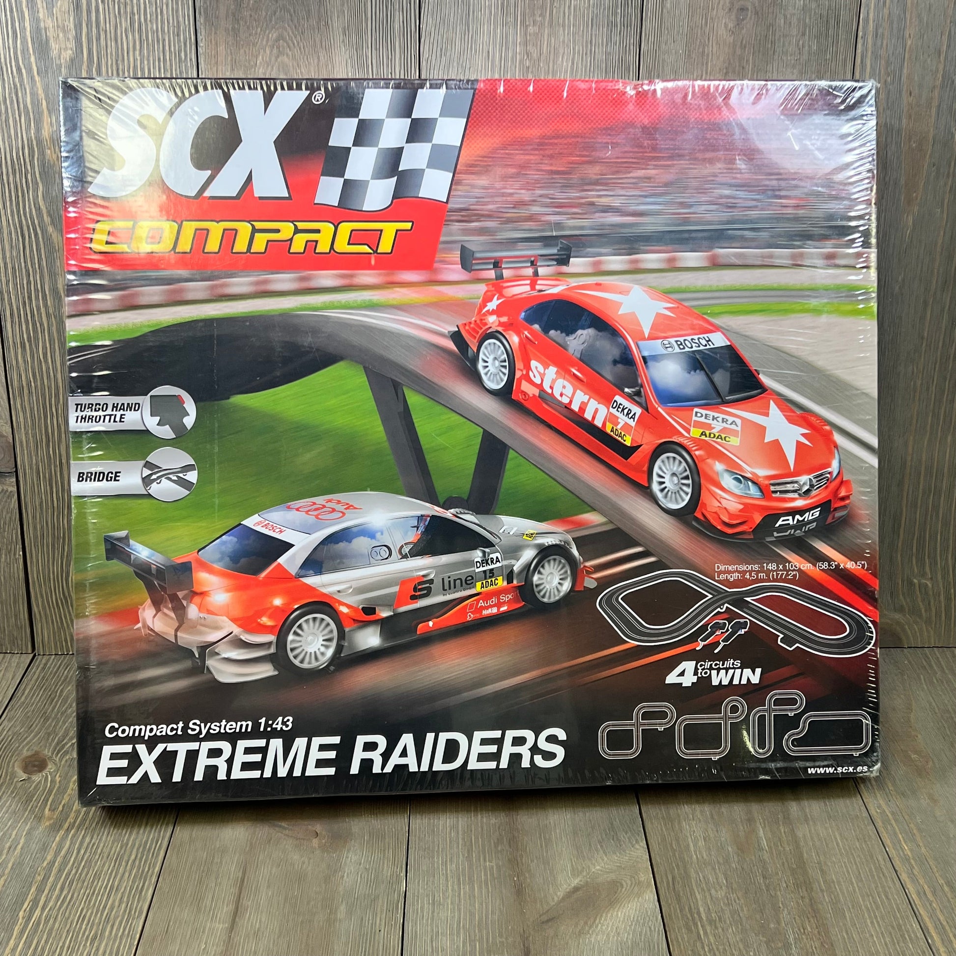 SCX Extreme Raiders 1:43 Scale Slot Car Set packaging featuring two sleek cars and race track layout.