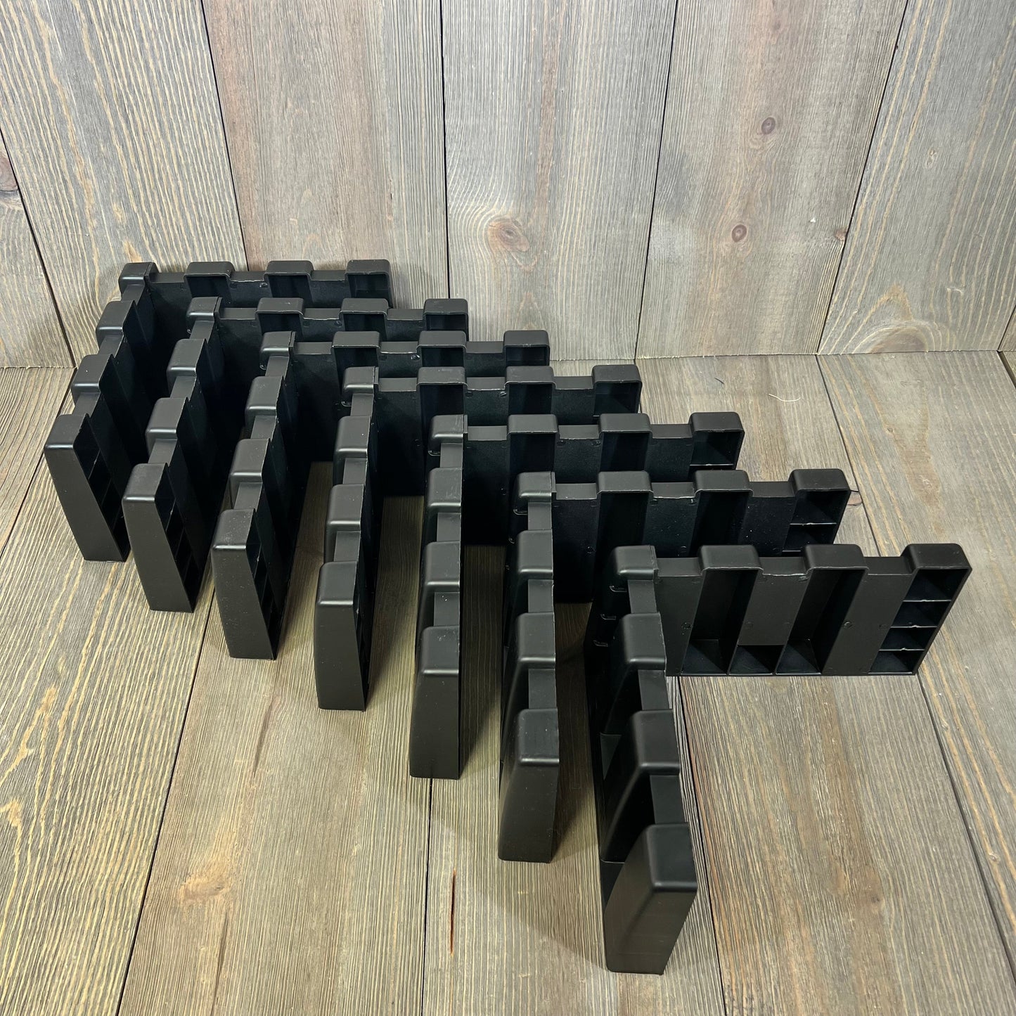 Black car trunk organizer blocks arranged on a wooden surface, ideal for SUVs and vans, enhancing cargo space management.