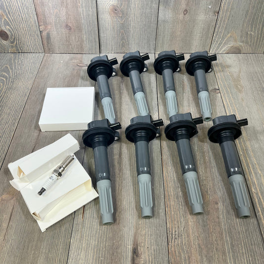 Set of 8 ignition coil packs and spark plugs for 2016-2017 Ford F-150 and Mustang V8 5.0L, displayed on wooden surface.