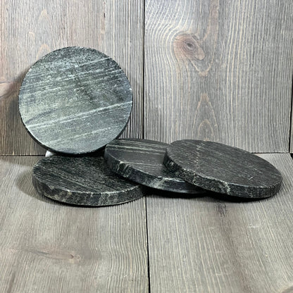 Natural black marble coasters set, 4-inch round design, heat tolerant, elegant surface perfect for protecting tabletops.