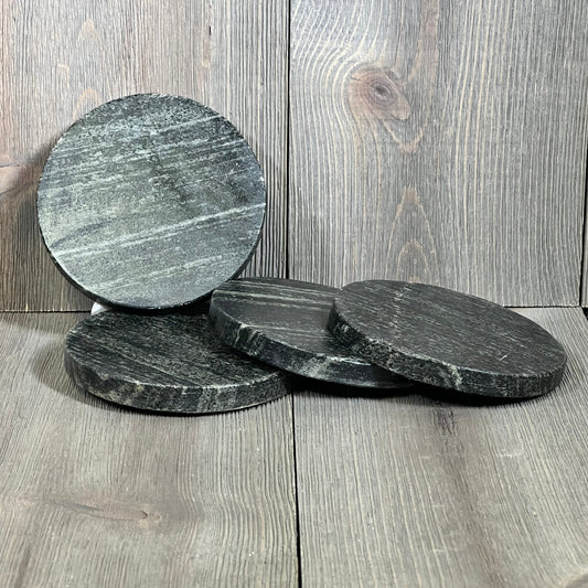 Natural black marble coasters set, 4-inch round design, heat tolerant, elegant surface perfect for protecting tabletops.