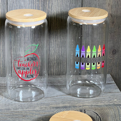 Teacher appreciation glass cups with wooden lids, featuring apple and crayon designs, ideal gifts for Teachers Week.