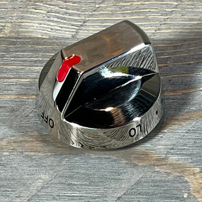 Shiny Samsung gas stove burner control knob with red indicator on textured surface.