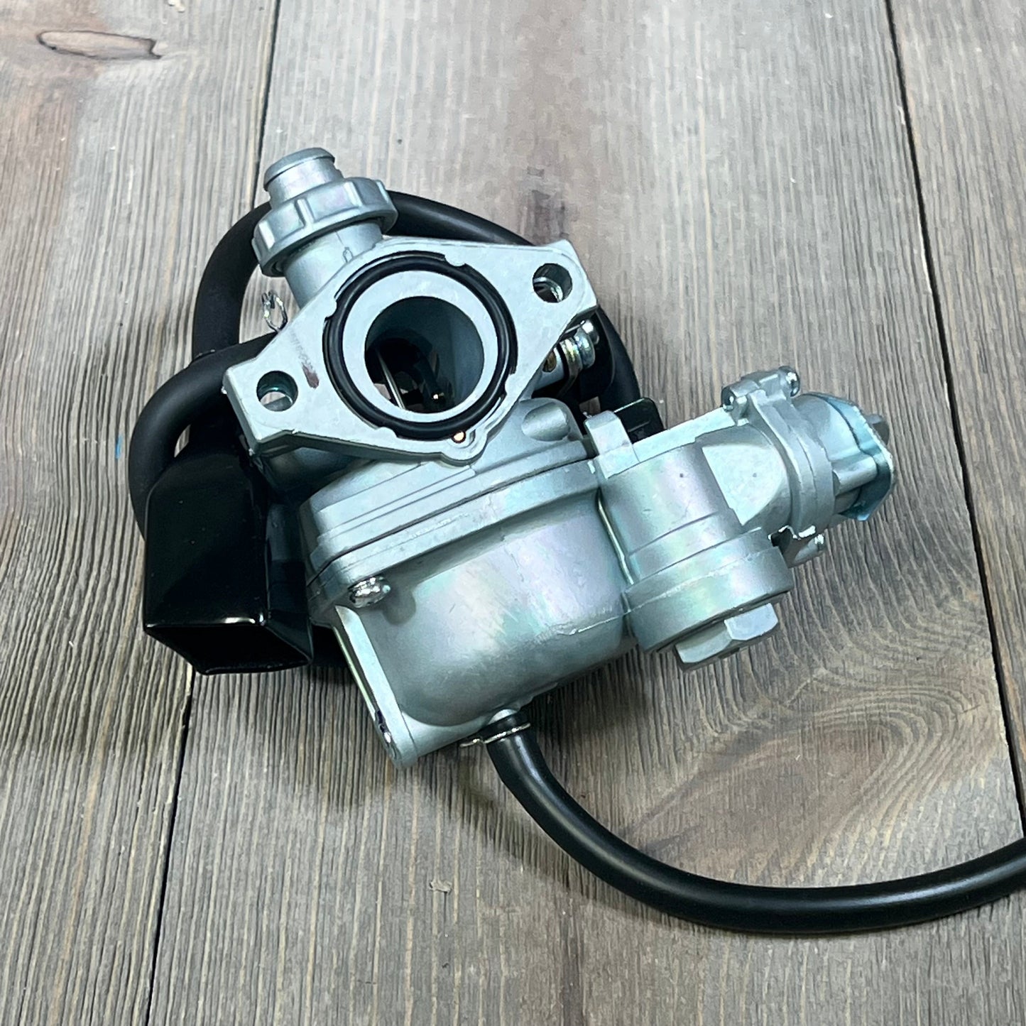 Honda TRX90 carburetor replacement on wooden surface, suitable for models 1993-2006.