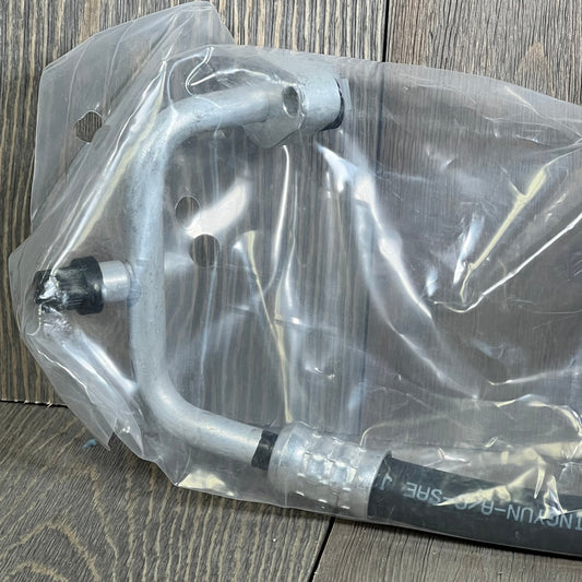 Premium A/C discharge line hose assembly for Jeep Wrangler 2007-2011, shown in protective packaging.