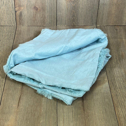 Sky blue faux wool throw pillow covers folded on wooden background, adding a soft, plush touch to farmhouse decor.