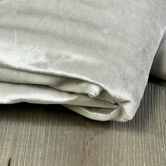 Folded MIULEE grey blackout curtain on wooden floor, showcasing soft fabric and thermal insulation for living room or bedroom.