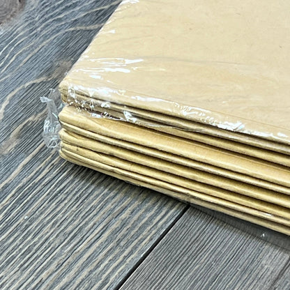 Stack of PACKHOME collapsible kraft gift boxes, wrapped in plastic, on a wooden surface, ready for assembly.