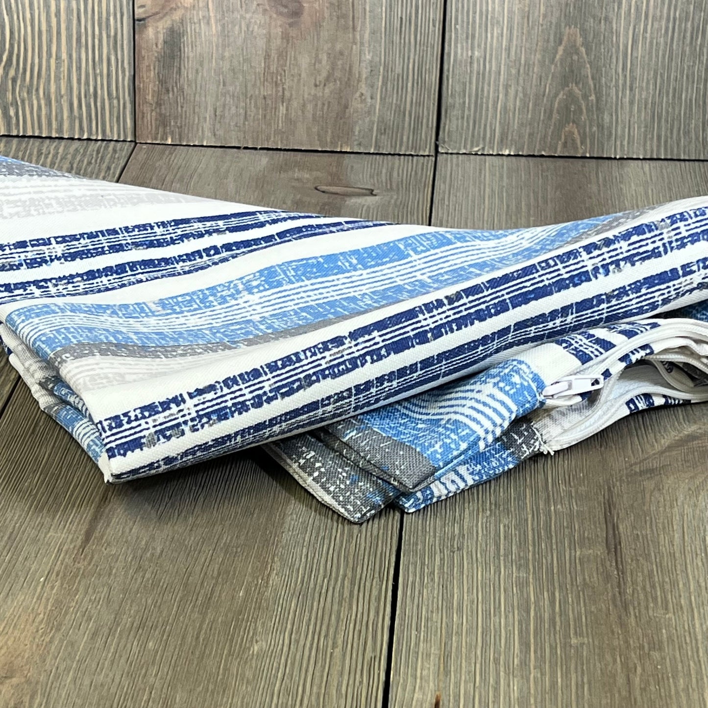 Stripe layered blue lumbar pillow covers on wood floor, perfect for patio or garden furniture, 12x20 inches, pack of 2.