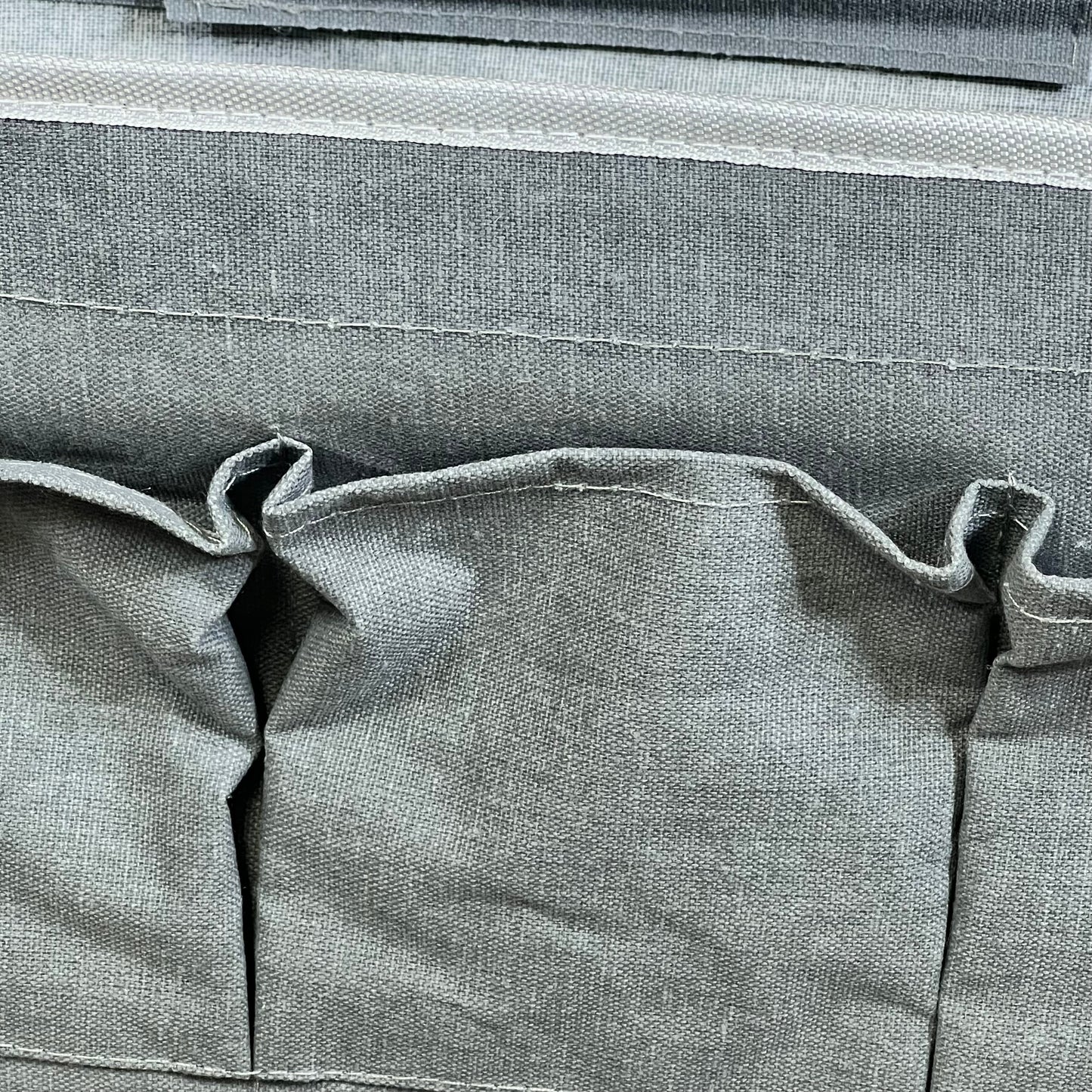 Gray linen wall organizer with three large pockets, ideal for kitchen or bedroom storage.
