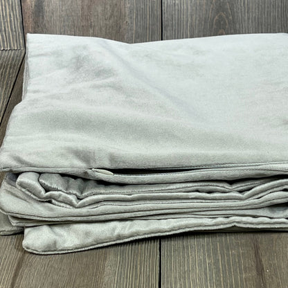 Cozy light-grey velvet pillow cases in 22x22 size, perfect for farmhouse decor, neatly folded on a wooden surface.