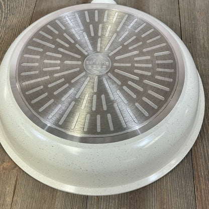 White Sensarte nonstick ceramic frying pan base, featuring induction-compatible design and PFAS-free material.