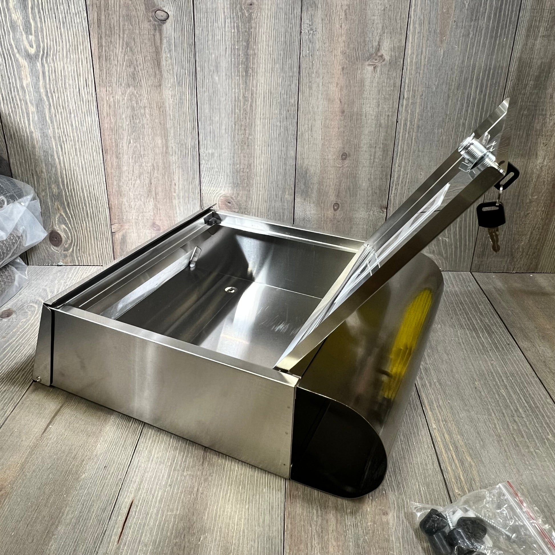 Wall-mounted stainless steel mailbox with open lid, showcasing spacious interior and secure key lock feature, ideal for large mail capacity.