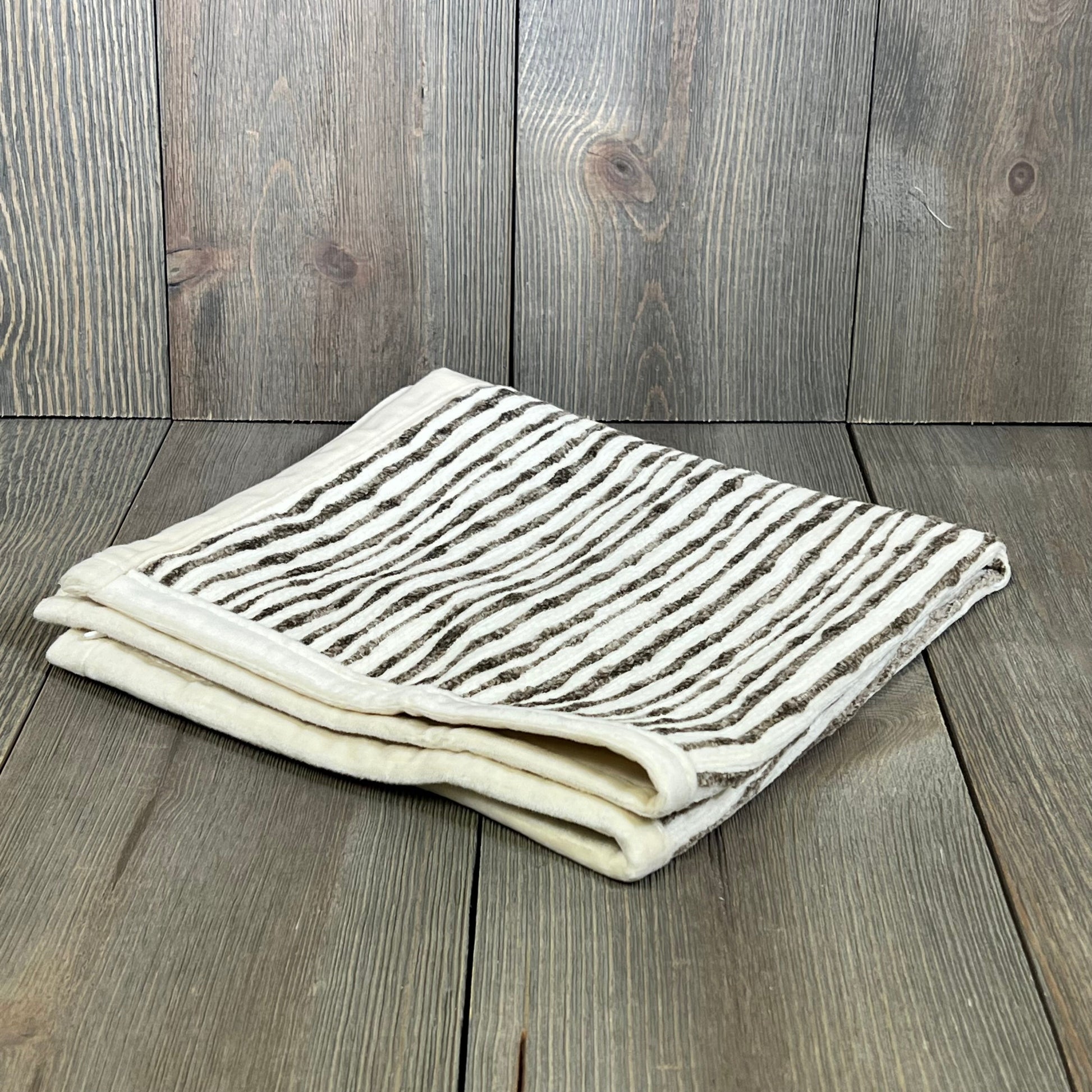 Dark brown chenille striped pillow cover folded on wooden surface, ideal for couch, chair, or bed decor, 18x18 inches.