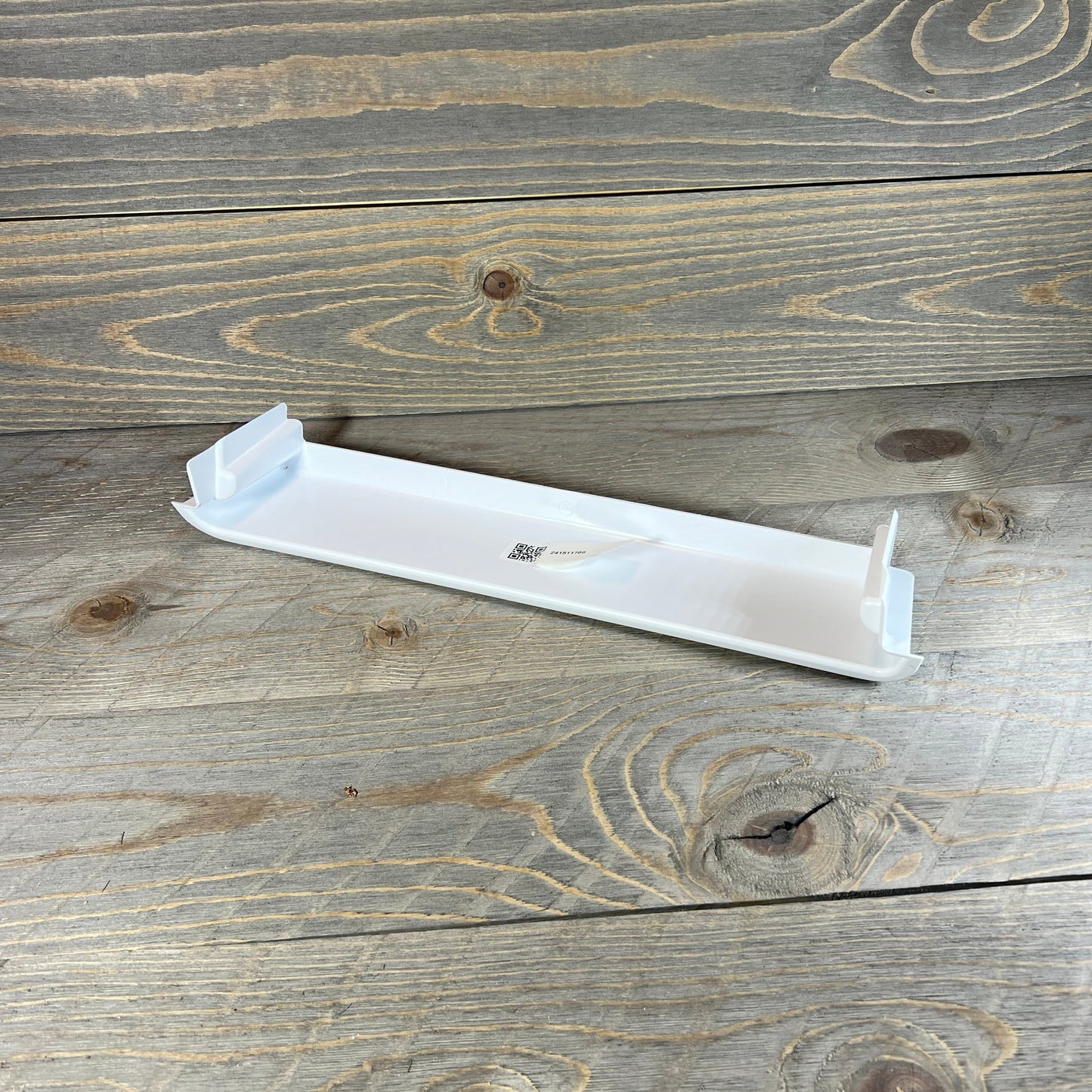 Sturdy Frigidaire refrigerator door shelf bin on wooden surface, ideal for maximizing fridge storage space.