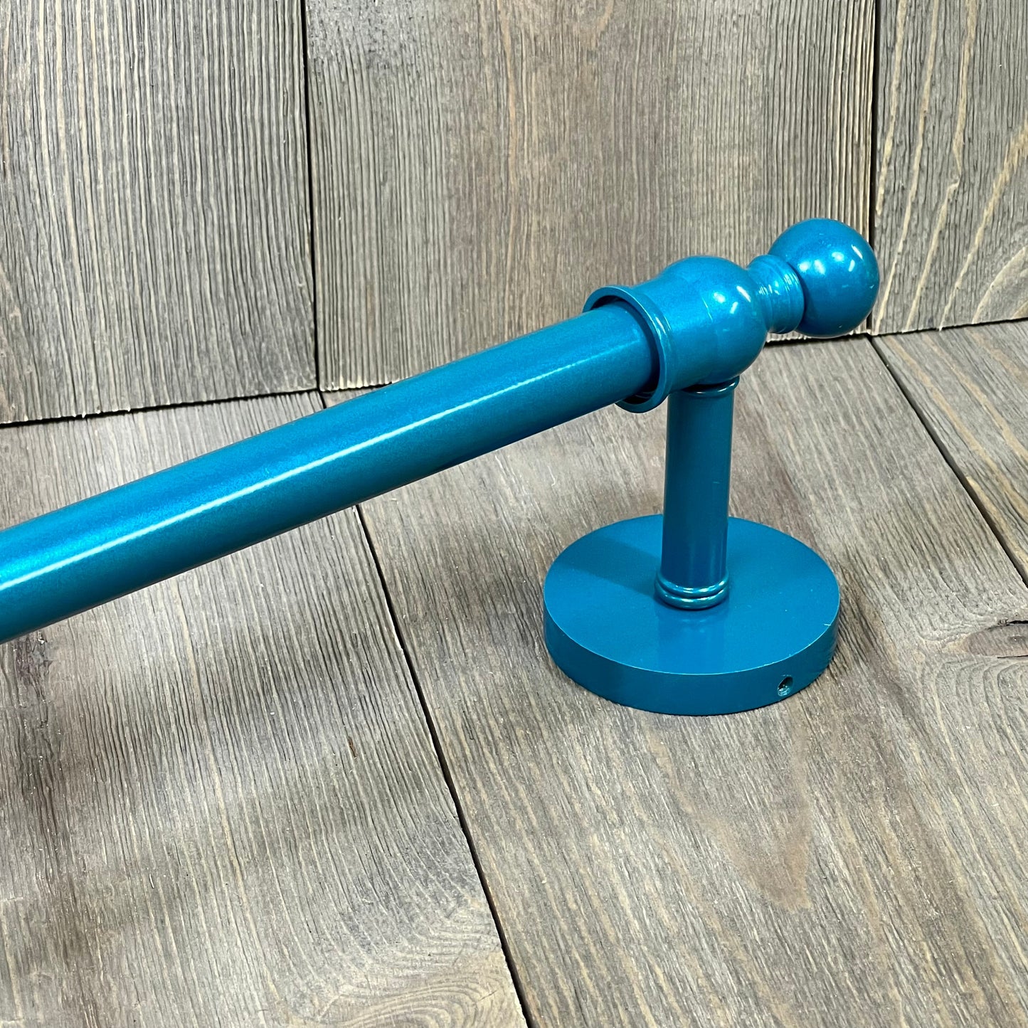 Teal towel bar from Allied Brass Skyline Collection, showcasing a sleek design on a wood-textured background.