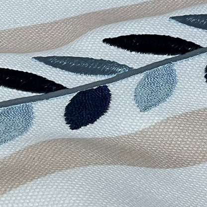 Close-up of Hofdeco lumbar pillow cover showing neutral tan embroidered leaf design with detailed piping.